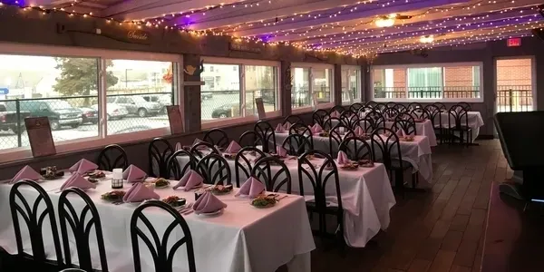 A restaurant with tables and chairs set up for dinner.