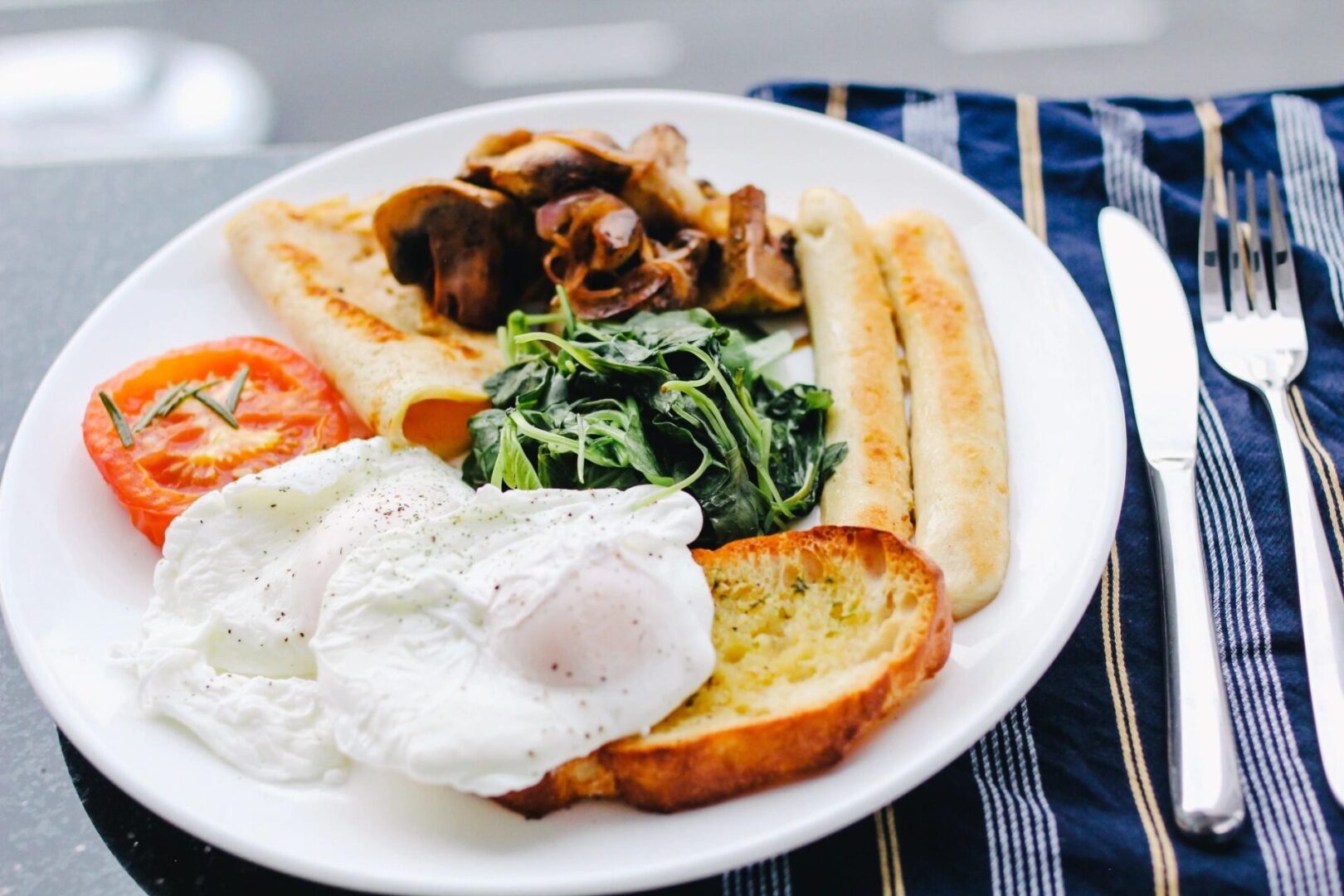 A plate of food with eggs, bread and vegetables.